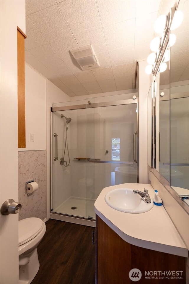 1122 G St, Centralia, WA 98531 - bathroom featuring wood finished floors, vanity, toilet, a stall shower, and wainscoting