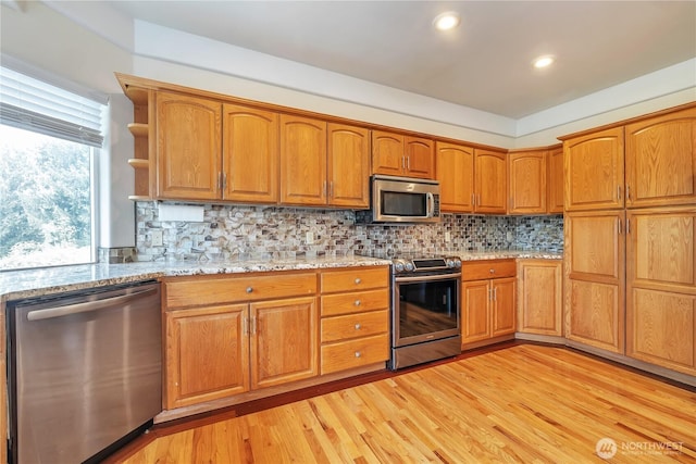 31637 107th Ave SE, Auburn, WA 98092 - kitchen with stainless steel appliances, light wood-style floors, open shelves, light stone counters, and brown cabinetry
