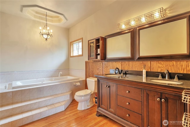 31637 107th Ave SE, Auburn, WA 98092 - bathroom featuring toilet, a bath, double vanity, wood finished floors, and a chandelier