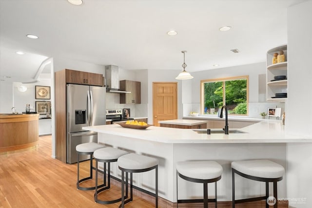 4102 205th Ave SE, Sammamish, WA 98075 - kitchen featuring stainless steel appliances, wall chimney exhaust hood, open shelves, a peninsula, and a breakfast bar