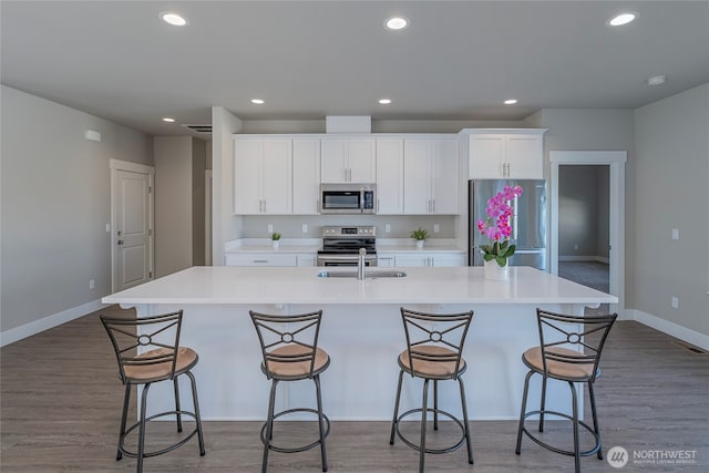 28 S Millbrook, East Wenatchee, WA 98802 - kitchen featuring appliances with stainless steel finishes, a large island, a sink, white cabinetry, and recessed lighting