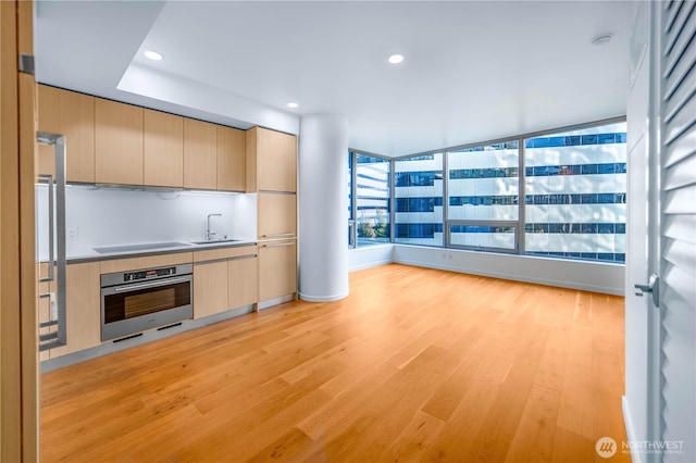 1808 Minor Ave Unit 912, Seattle, WA 98101 - kitchen with stainless steel oven, a sink, light wood-style floors, recessed lighting, and modern cabinets