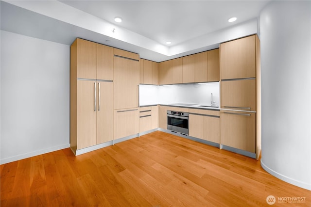 1808 Minor Ave Unit 912, Seattle, WA 98101 - kitchen with stainless steel oven, a sink, light wood-style floors, baseboards, and recessed lighting