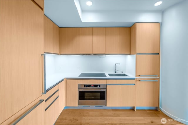 1808 Minor Ave Unit 912, Seattle, WA 98101 - kitchen featuring stainless steel oven, light brown cabinets, black electric stovetop, a sink, and recessed lighting