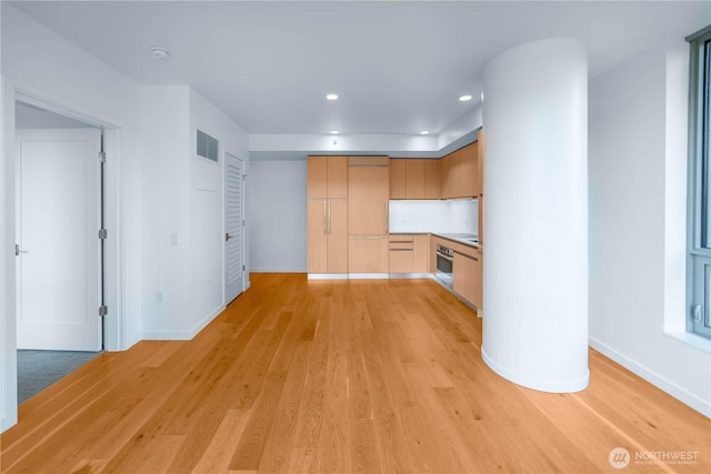 1808 Minor Ave Unit 912, Seattle, WA 98101 - kitchen featuring stainless steel oven, baseboards, light wood-style flooring, recessed lighting, and light brown cabinetry