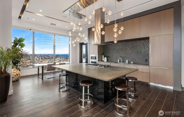 1808 Minor Ave Unit 912, Seattle, WA 98101 - kitchen featuring modern cabinets, stainless steel appliances, dark wood-type flooring, a breakfast bar, and a large island