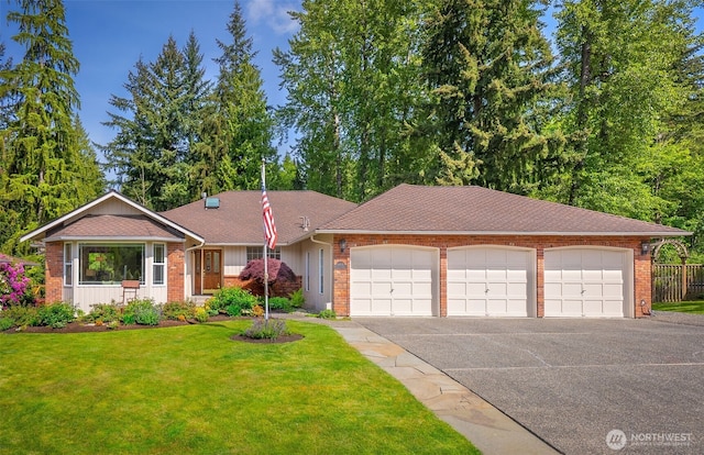 14431 Cascade Dr SE, Snohomish, WA 98296 - view of front of home with an attached garage, asphalt driveway, brick siding, and a shingled roof