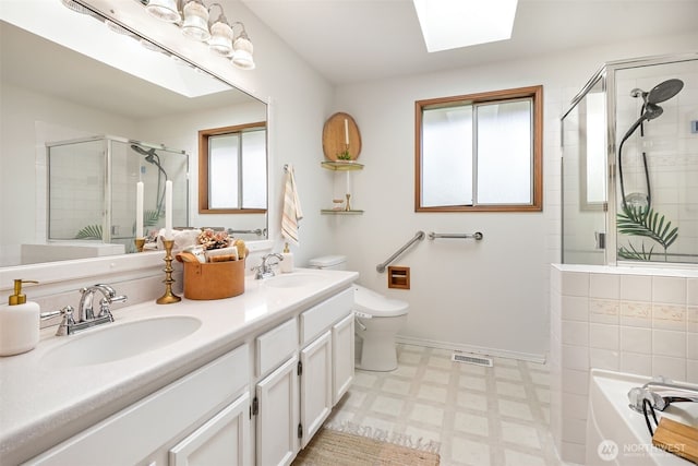 14431 Cascade Dr SE, Snohomish, WA 98296 - full bathroom with a shower stall, a skylight, tile patterned floors, toilet, and double vanity