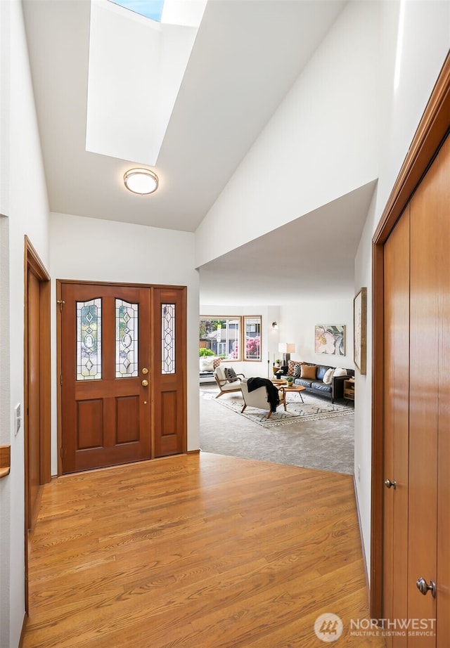 14431 Cascade Dr SE, Snohomish, WA 98296 - foyer entrance featuring a skylight, high vaulted ceiling, and light wood-type flooring