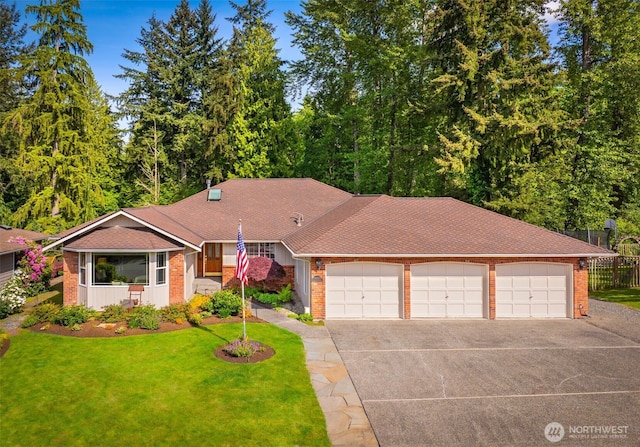 14431 Cascade Dr SE, Snohomish, WA 98296 - view of front of house featuring an attached garage, concrete driveway, brick siding, and roof with shingles