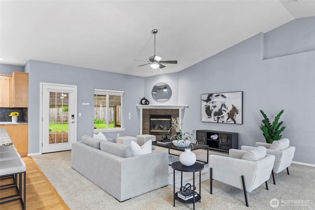 10810 63rd Ave NW, Gig Harbor, WA 98332 - living room with ceiling fan, a tiled fireplace, light wood-style floors, vaulted ceiling, and baseboards