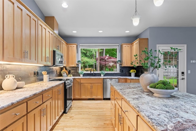 10810 63rd Ave NW, Gig Harbor, WA 98332 - kitchen featuring appliances with stainless steel finishes, light wood-style floors, a sink, light stone countertops, and tasteful backsplash