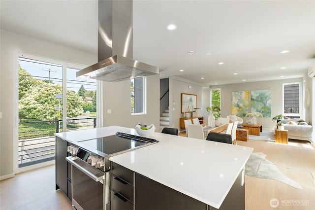 1801 NW 65th St Unit C, Seattle, WA 98117 - kitchen with stainless steel range with electric cooktop, island exhaust hood, a kitchen island, light wood finished floors, and recessed lighting