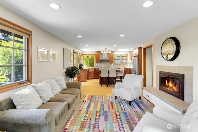 living room featuring recessed lighting, light wood-type flooring, and a fireplace