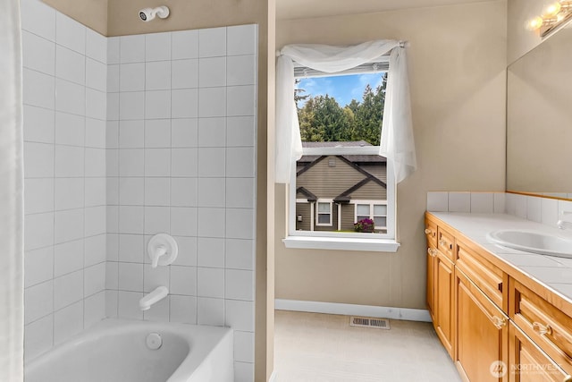 bathroom with vanity, baseboards, and bathing tub / shower combination