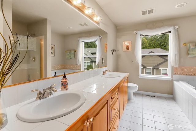 bathroom with tile patterned flooring, healthy amount of natural light, a shower with shower door, and a garden tub