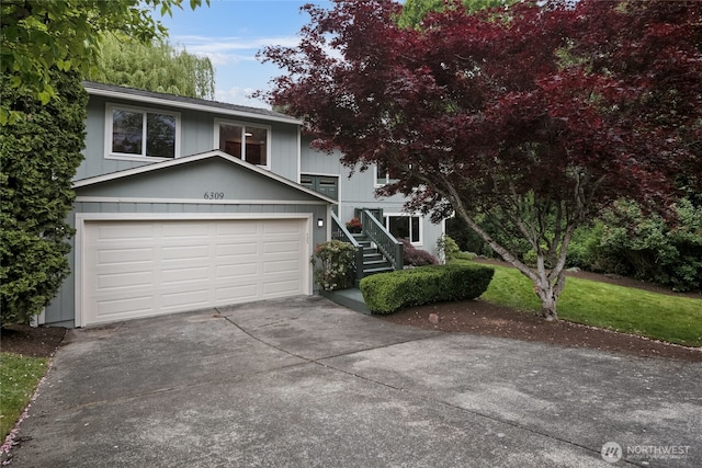 view of front of house featuring concrete driveway and stairway