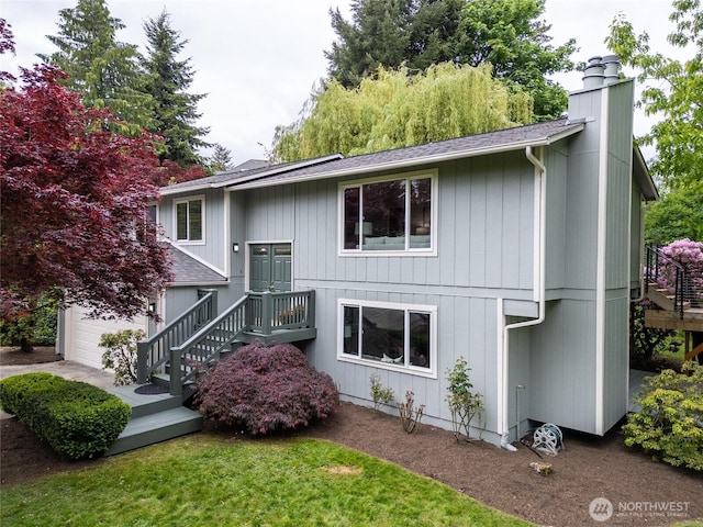 split foyer home with roof with shingles, a chimney, and stairway