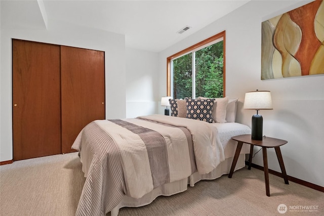 bedroom featuring light carpet, a closet, and baseboards