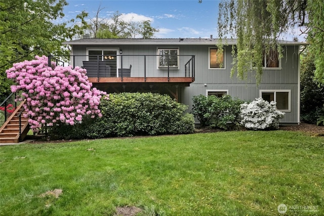 back of property featuring a lawn, a balcony, a chimney, and stairway
