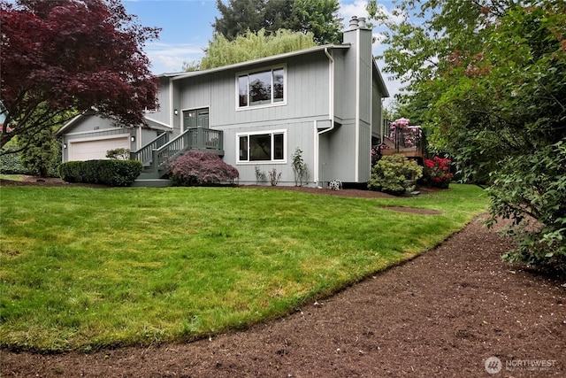 view of front of home with a chimney, a front yard, and a garage