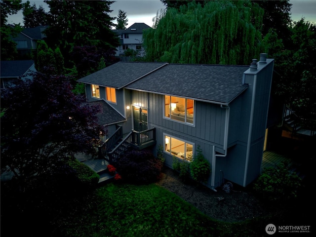 6309 115th Ct SE, Bellevue, WA 98006 - back of house with roof with shingles, a chimney, board and batten siding, and a lawn