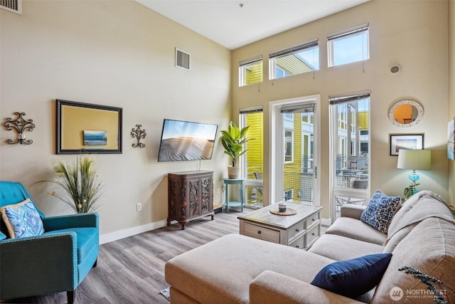 1705 Dock St Unit 520, Tacoma, WA 98402 - living room featuring wood finished floors, a towering ceiling, and baseboards