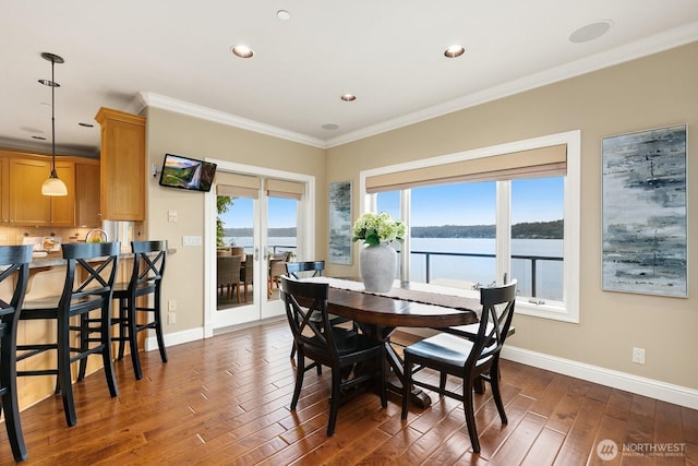 dining room featuring dark wood-type flooring, baseboards, crown molding, and recessed lighting