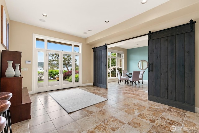 entryway featuring a barn door, baseboards, recessed lighting, and french doors