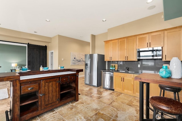 kitchen with stainless steel appliances, light brown cabinets, backsplash, a sink, and recessed lighting