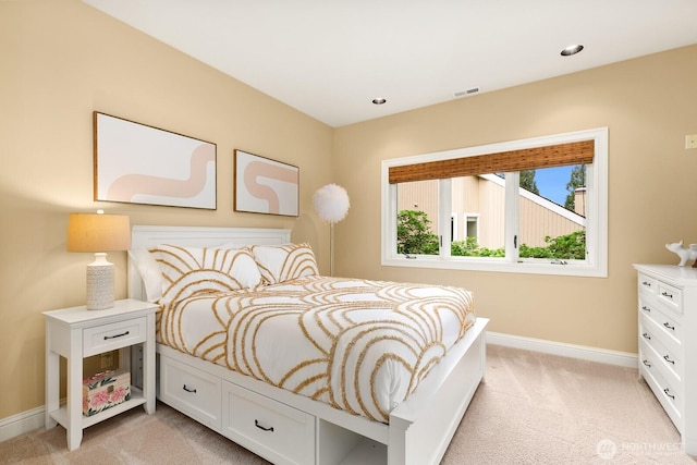 bedroom with light colored carpet and baseboards