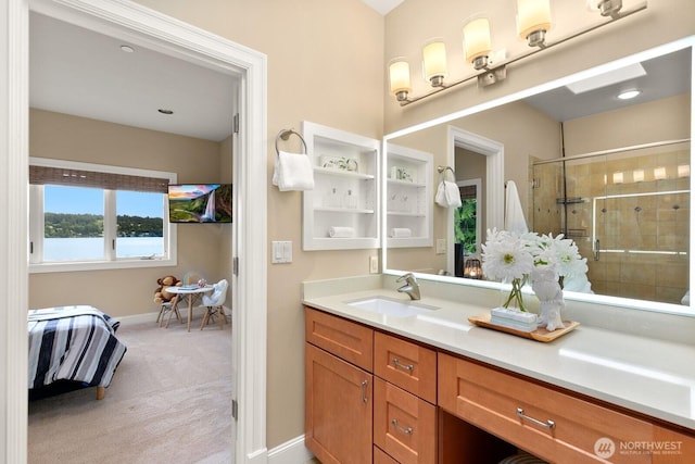 ensuite bathroom with a stall shower, vanity, and baseboards
