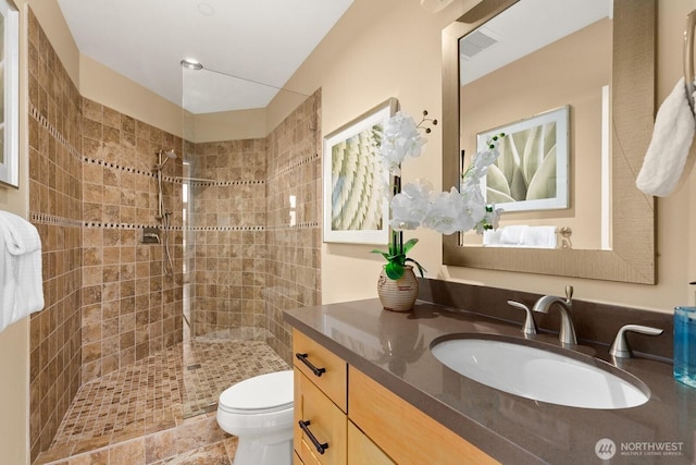 full bathroom featuring a walk in shower, vanity, and toilet