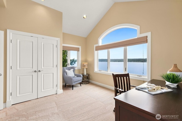 office with lofted ceiling, light carpet, baseboards, and a water view
