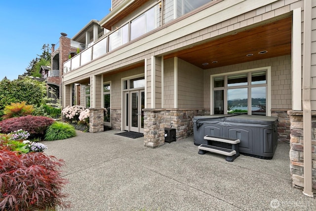 view of patio / terrace featuring a hot tub and french doors