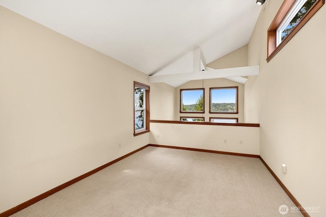 spare room featuring light colored carpet, baseboards, and lofted ceiling