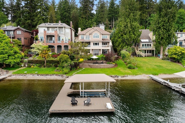 dock with a water view, a yard, and a residential view