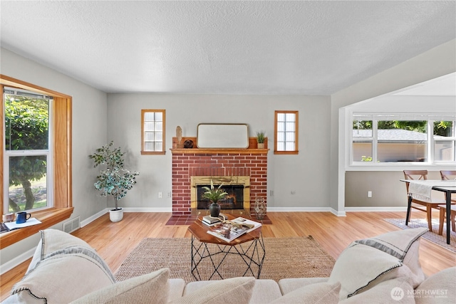 1510 N Mason Ave, Tacoma, WA 98406 - living room with wood finished floors, healthy amount of natural light, a fireplace, and a textured ceiling
