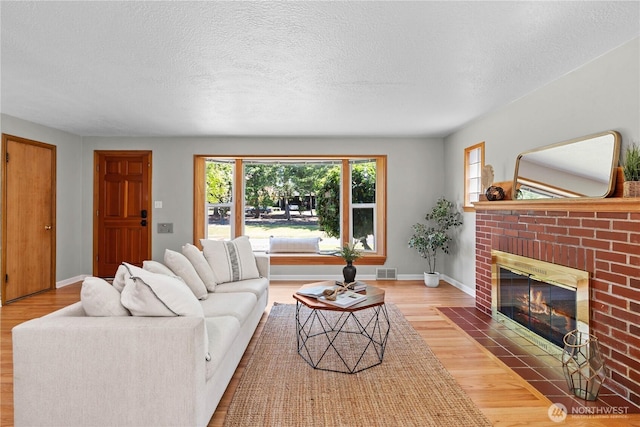 1510 N Mason Ave, Tacoma, WA 98406 - living room with wood finished floors, a fireplace, baseboards, and a textured ceiling