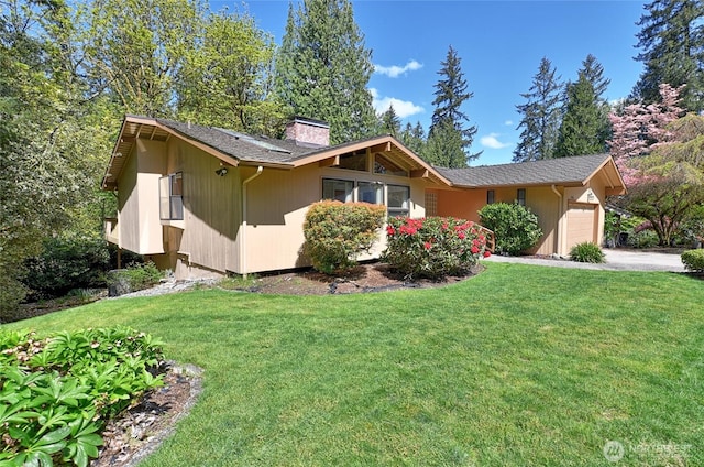 ranch-style house with a garage, a chimney, a front yard, and driveway