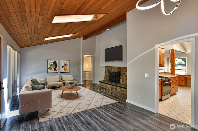 living area featuring a fireplace, wooden ceiling, wood finished floors, baseboards, and high vaulted ceiling