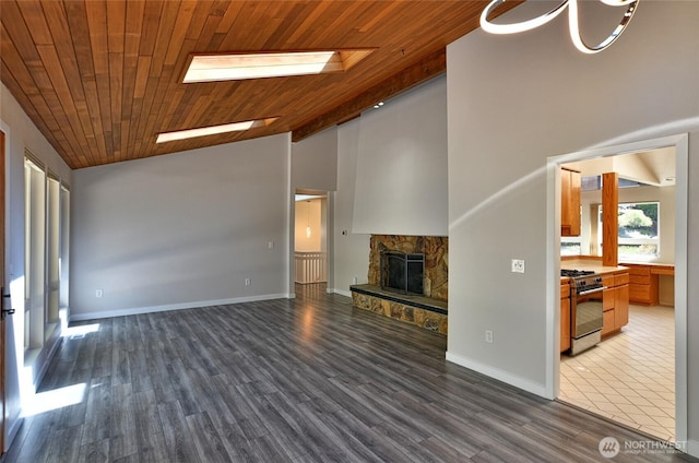 unfurnished living room featuring a stone fireplace, wooden ceiling, high vaulted ceiling, wood finished floors, and baseboards