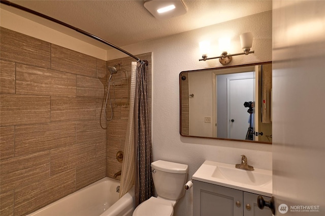 bathroom featuring toilet, shower / bath combo, vanity, and a textured ceiling