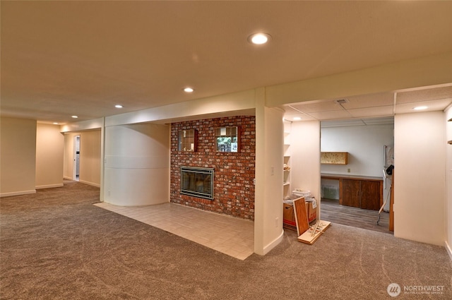 finished basement featuring carpet floors, a brick fireplace, recessed lighting, and baseboards