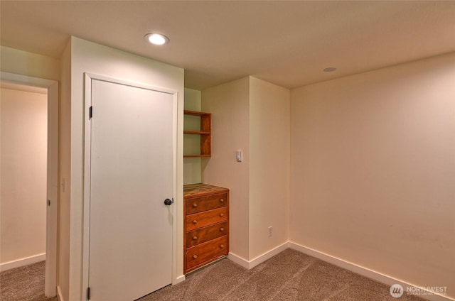 unfurnished bedroom featuring carpet flooring, baseboards, recessed lighting, and a closet