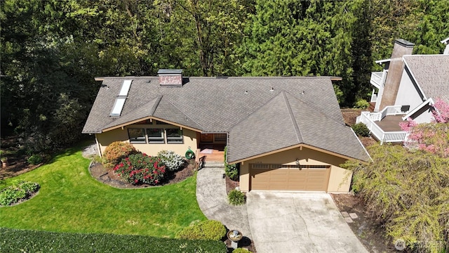 view of front of property featuring a shingled roof, a front yard, driveway, and stucco siding