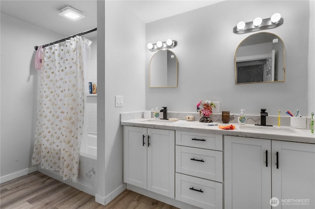 810 SW 124th St, Burien, WA 98146 - full bath featuring wood finished floors, double vanity, shower / bath combo with shower curtain, and baseboards