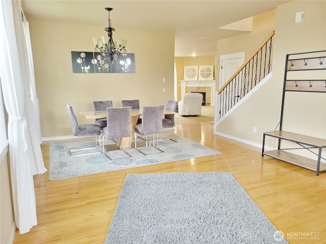 dining area with wood finished floors, stairway, and baseboards