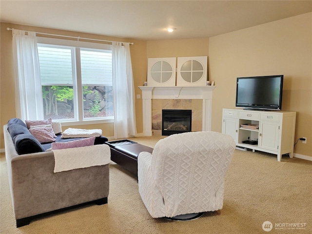 living room featuring light colored carpet, a fireplace, and baseboards