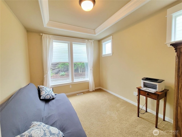 living area featuring a tray ceiling, carpet, baseboards, and ornamental molding